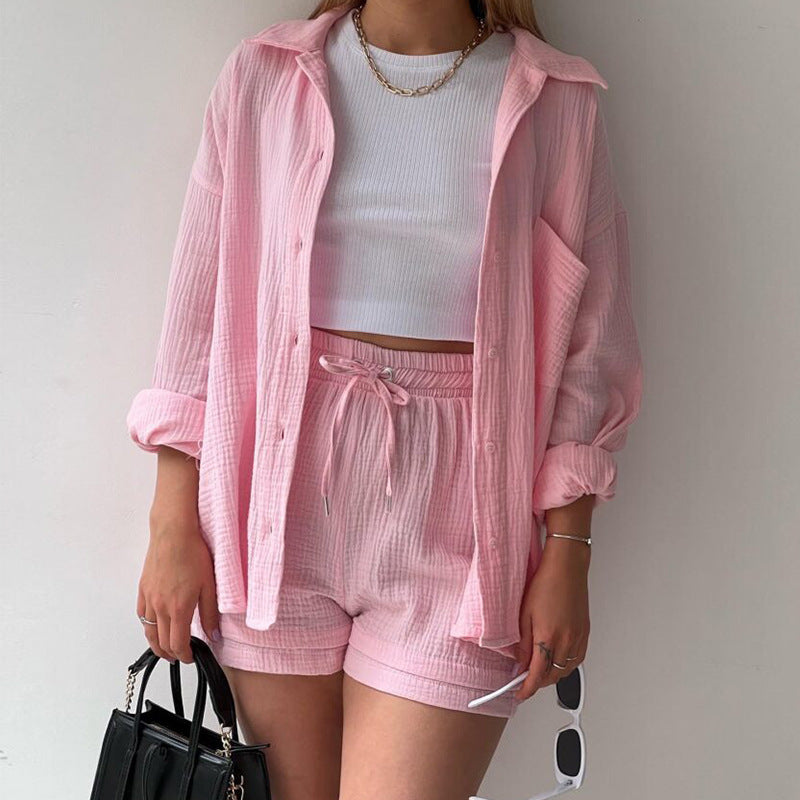 A two-piece set of wrinkled fabric shirt and high-waisted shorts