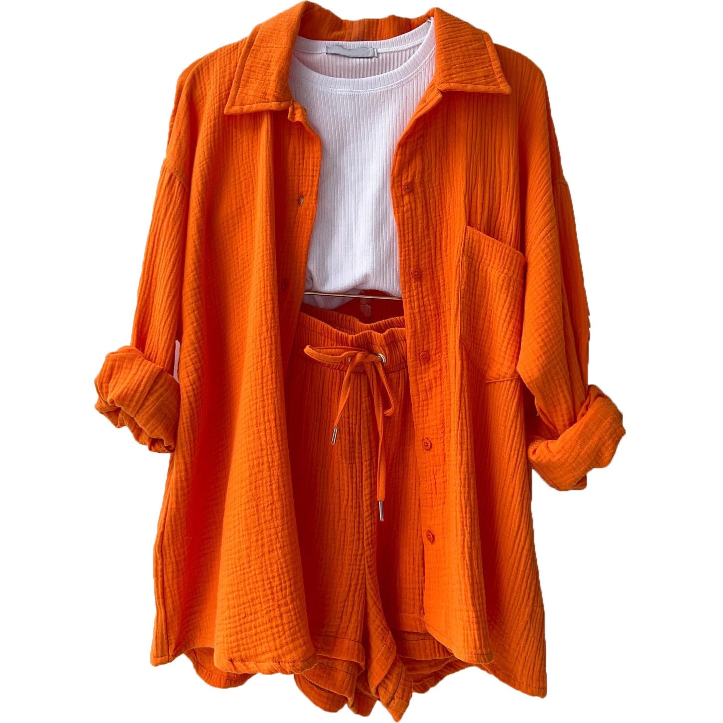 A two-piece set of wrinkled fabric shirt and high-waisted shorts