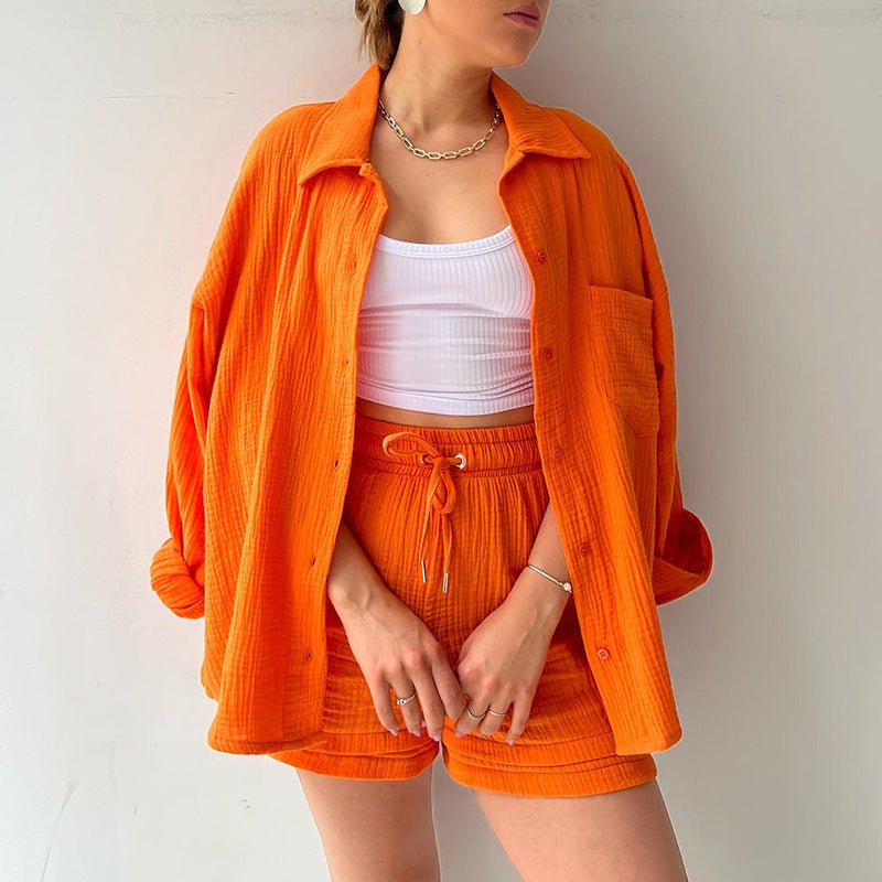 A two-piece set of wrinkled fabric shirt and high-waisted shorts