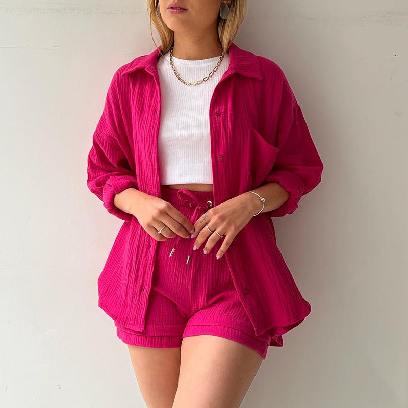 A two-piece set of wrinkled fabric shirt and high-waisted shorts